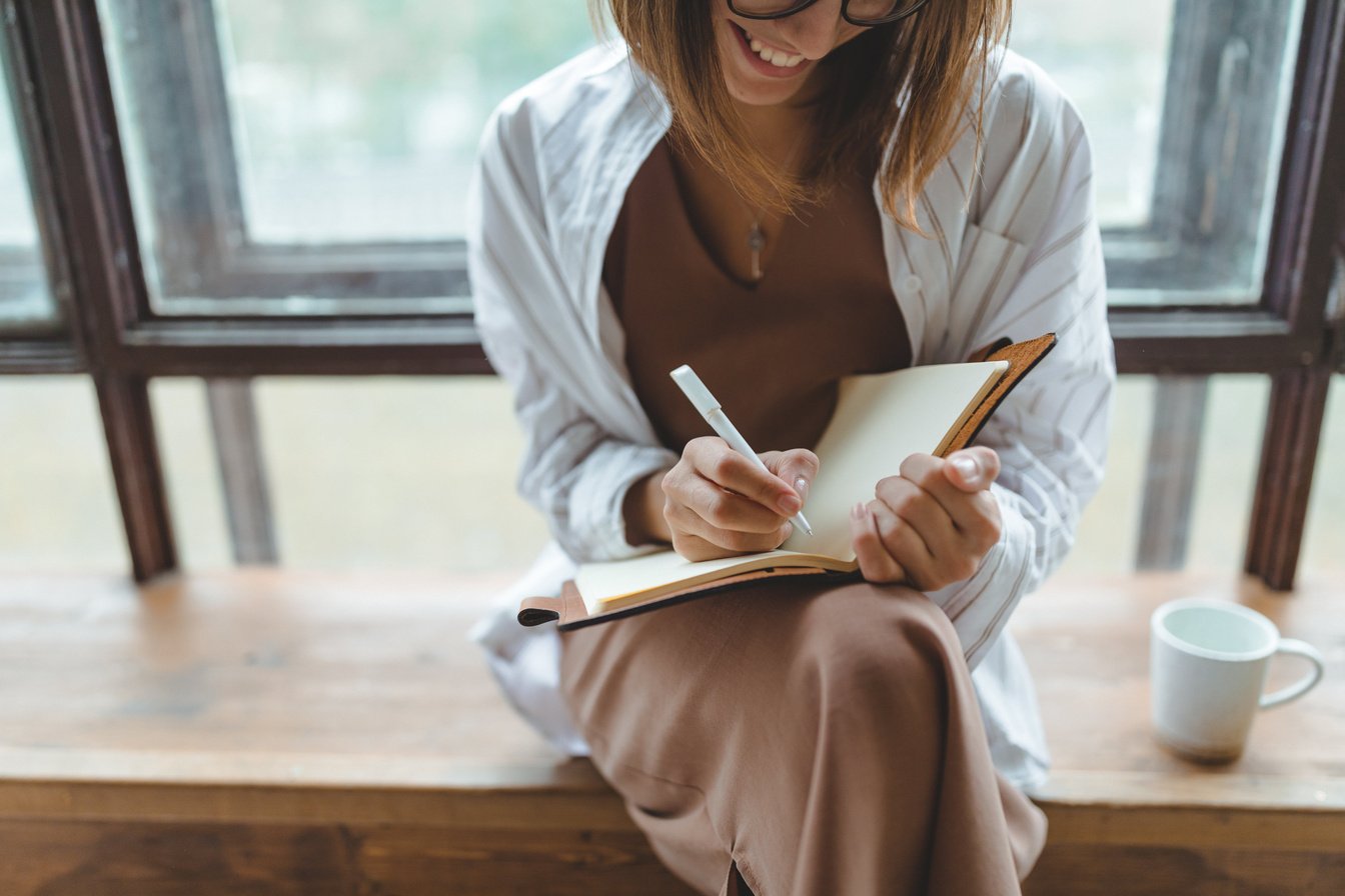 Woman Writing On A Notebook