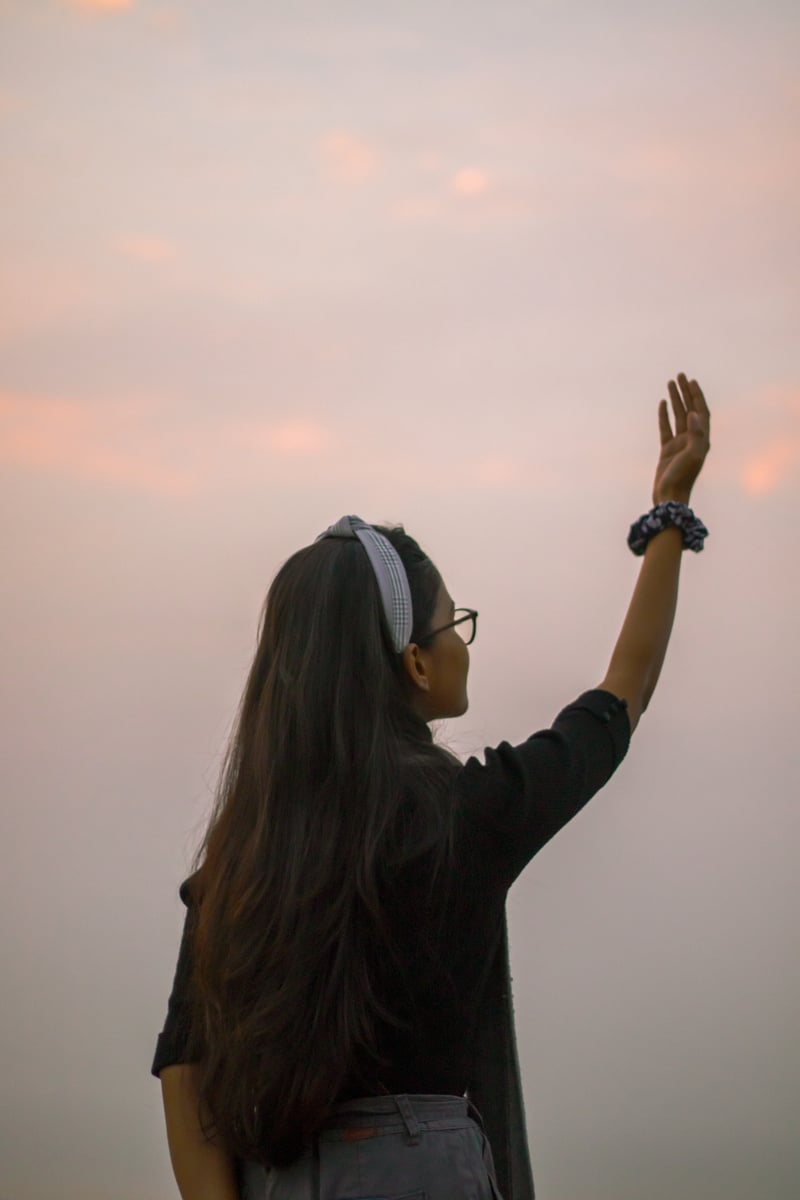 Anonymous girl against sunset sky